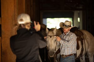 Photographer taking photos of cowboy with horse