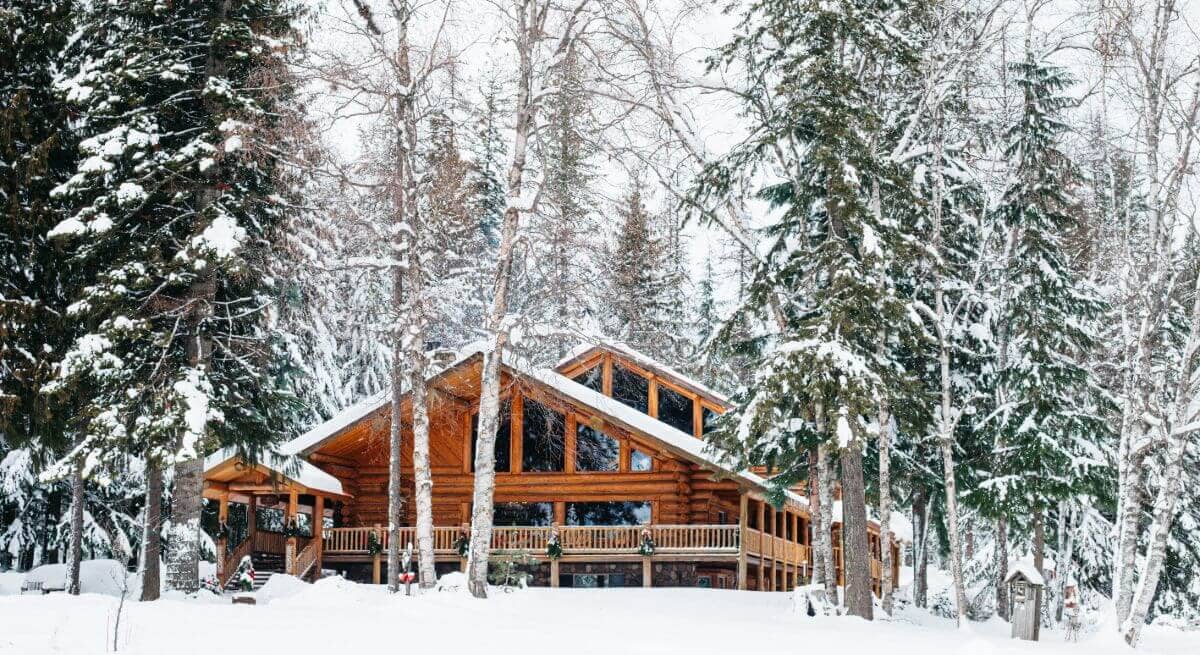 large log lodge set in a snow covered forest
