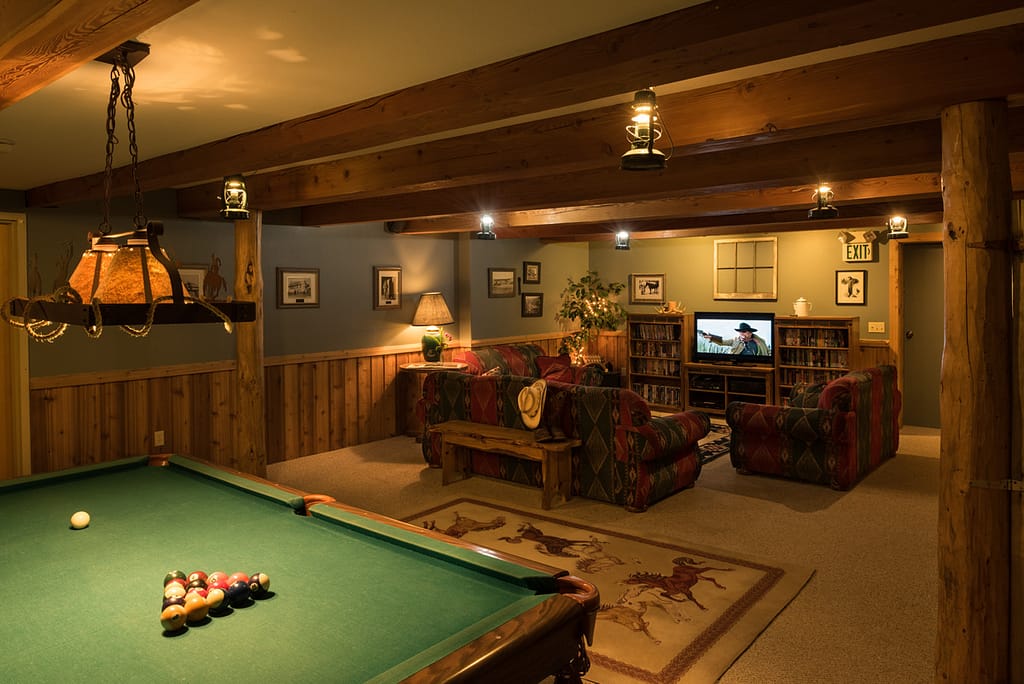 Lodge Rec room with green pool table, lantern lights, couches, tv and movies