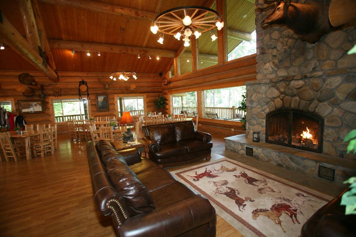 large river rock fireplace with leather couches and log tables and chairs
